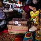 Penjual memperlihatkan minyak goreng kemasan di kiosnya Pasar Kebayoran Lama, Jakarta, Rabu (19/1/2022). Pemerintah resmi mengimplementasikan kebijakan minyak goreng satu harga Rp14.000 per liter untuk semua jenis kemasan mulai hari ini. (Liputan6.com/Johan Tallo)