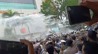 Polisi menyemprotkan watercanon di tengah bentrok mahasiswa di depan gedung DPRD Sumsel (Liputan6.com / Nefri Inge)