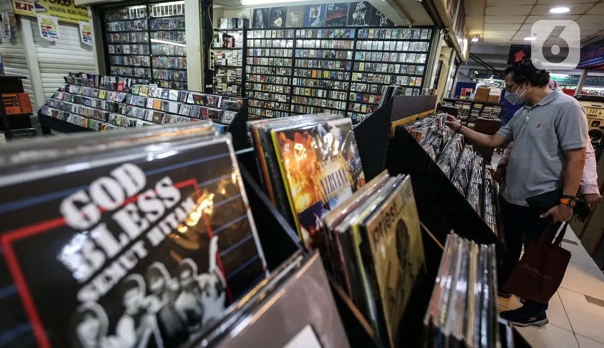 Pecinta musik memilah Piringan Hitam, CD, dan Kaset pita di toko "Wow Record Store", Blok M Squere, Jakarta, Jumat (12/3/2021). Pedagang Piringan Hitam, CD, dan Kaset Pita ini bertahan ditengah Perkembangan era digital dan Pandemi. (Liputan6.com/Johan Tallo)