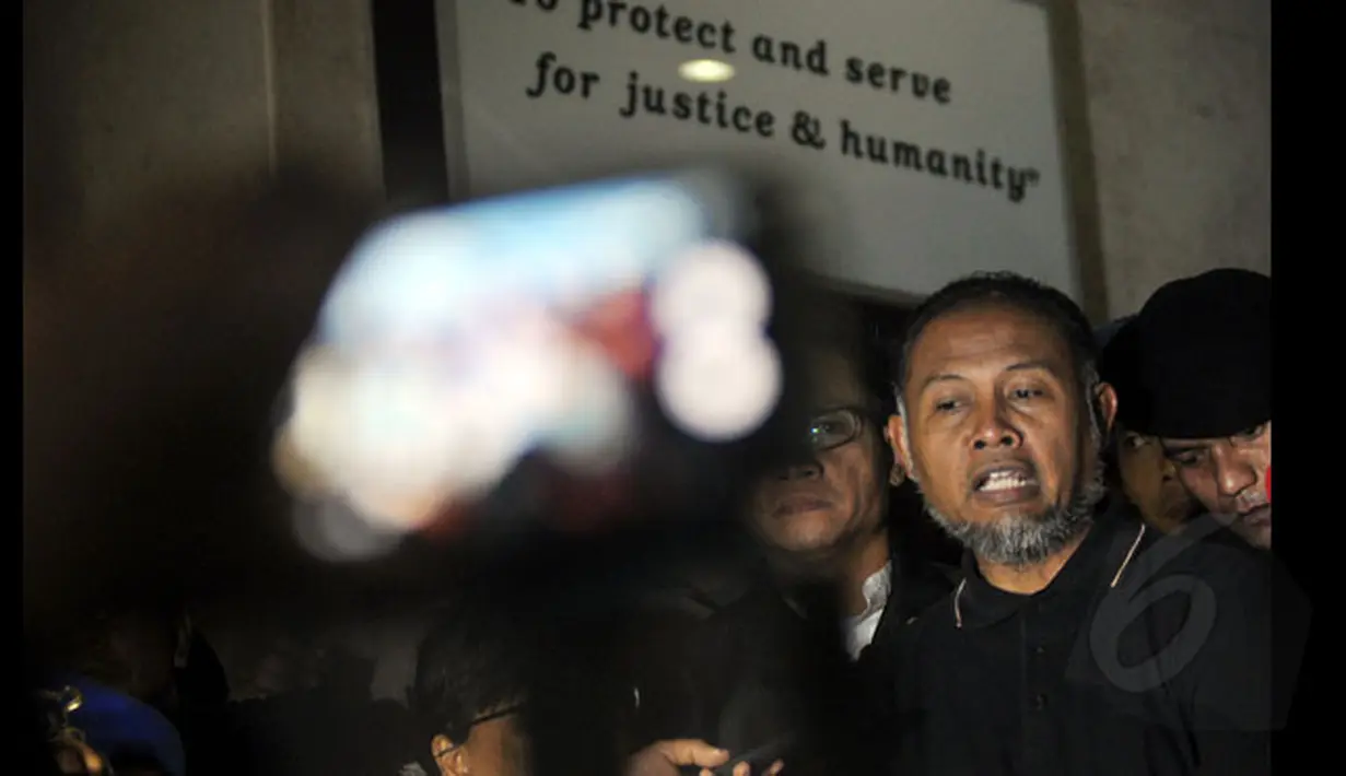 Wakil Ketua KPK, Bambang Widjojanto keluar dari gedung Bareskrim Mabes Polri, Jakarta, Sabtu dini hari (24/1/2015). Tampak, Bambang Widjojanto memberikan keterangan kepada wartawan di depan gedung Bareskrim Mabes Polri. (Liputan6.com/Miftahul Hayat)