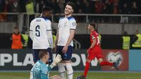 Declan Rice tertawa setelah rekan setimnya di Timnas Inggris, Jordan Pickford, kebobolan oleh pemain Makedonia Utara&nbsp;saat bertanding di National Arena Todor Proeski dalam lanjutan Kualifikasi Euro 2024, Selasa (21/11/2023) dini hari WIB. (AP Photo/Boris Grdanoski)