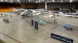 Petugas mempersiapkan pesawat bertenaga surya, Solar Impulse 2 untuk uji penerbangan di bandara Kalaeloa, Hawaii, Kamis (3/3). Pesawat ini rencananya akan melakukan perjalanan keliling dunia untuk mempromosikan energi terbarukan. (AFP PHOTO/EUGENE Tanne)