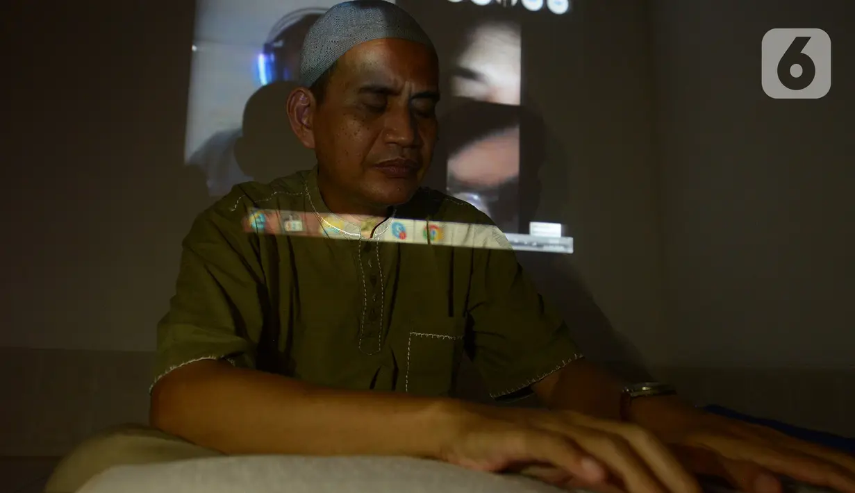 Seorang tunanetra membaca Al-Quran braille saat tadarus bersama secara online lewat aplikasi di Jakarta, Selasa (12/5/2020). Di tengah pandemi COVID-19 ini, sejumlah tunanetra melakukan tadarus bersama guna meningkatkan keimanan dan ketakwaan di bulan Ramadan 1441 Hijriah. (merdeka.com/Imam Buhori)