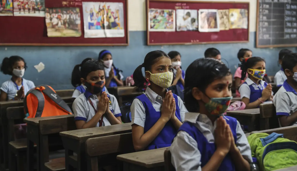 di sebuah sekolah di Mumbai, India, Rabu (15/12/2021). Setelah ditutup selama hampir 20 bulan karena pandemi virus corona, sekolah di Mumbai dibuka kembali untuk kelas 1 sampai 7. (AP Photo/Rafiq Maqbool)