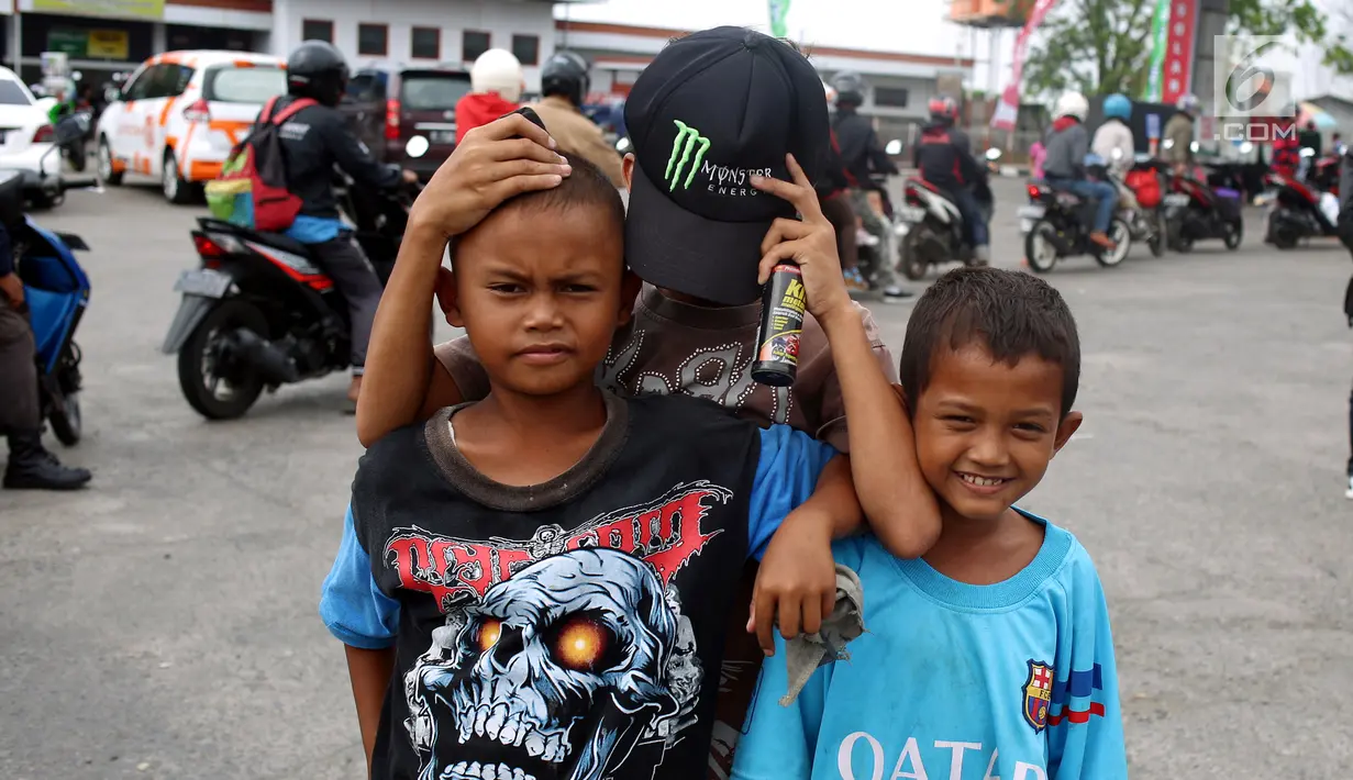 Anak - anak di SPBU Tanjung Pantura - Brebes mengais rejeki untuk membersihakan motor yang di kendarai pemudik dari Jakarta menuju kampung halamannya, Kamis (22/6). (Liputan6.com/Johan Tallo)