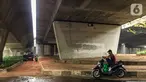 Pengendara motor beristirahat di jalur putar balik Jalan Gatot Soebroto, kawasan Kuningan, Jakarta, Selasa (12/11/2019). Jalur yang kini hanya bisa dilalui kendaraan roda dua itu menjadi lokasi sebagian pemotor beristirahat karena teduh tertutup jalan tol dalam kota. (Liputan6.com/Immanuel Antonius)