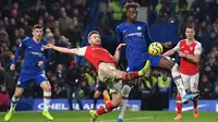 Striker Chelsea, Tammy Abraham, berebut bola dengan bek Arsenal, Shkodran Mustafi, pada laga Premier League pekan ke-24 di Stamford Bridge, London, Rabu (22/1). Arsenal tahan imbang Chelsea 2-2. (AFP/Ben Stansall)