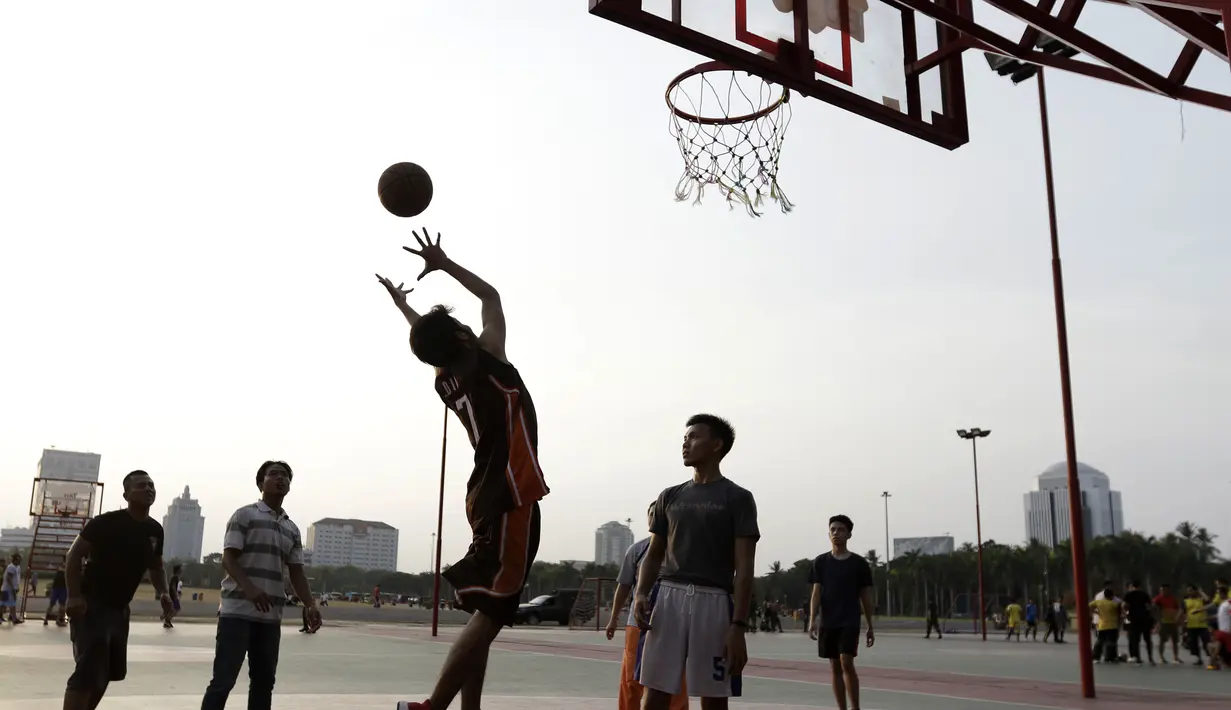 Sejumlah warga bermain basket di kawasan Monas, Jakarta, Jumat (11/10). Kawasan Monas menjadi pilihan warga Jakarta dan pekerja ibu kota untuk berolahraga sore. (Bola.com/Yoppy Renato)