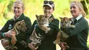 Tiga petugas Kebun Binatang menggendong anak harimau Sumatera di dalam kandangnya di Kebun Binatang ,Sydney, Australia, Jumat (29/3/2019). Ketiga anak Harimau Sumatera yang berjenis kelamin dua betina dan satu pejantan itu lahir pada 17 Januari 2019. (PETER PARKS / AFP)