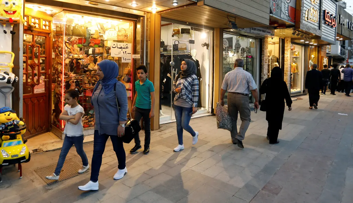 Para pejalan kaki melewati toko-toko di Baghdad, Irak, 9 April 2019. (REUTERS/Khalid al-Mousily)
