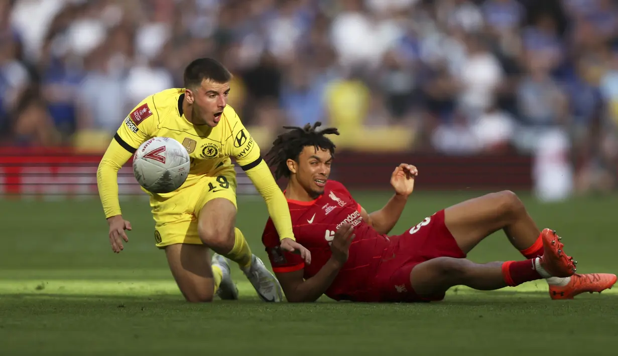 <p>Bek Liverpool Trent Alexander-Arnold (kanan) dan gelandang Chelsea Mason Mount terjatuh saat berebut bola pada partai final Piala FA di Stadion Wembley pada Minggu (16/5/2022) dini hari WIB. Liverpool sukses menjuarai Piala FA 2021/2022. The Reds mengalahkan Chelsea lewat adu penalti. (AP Photo/Ian Walton)</p>