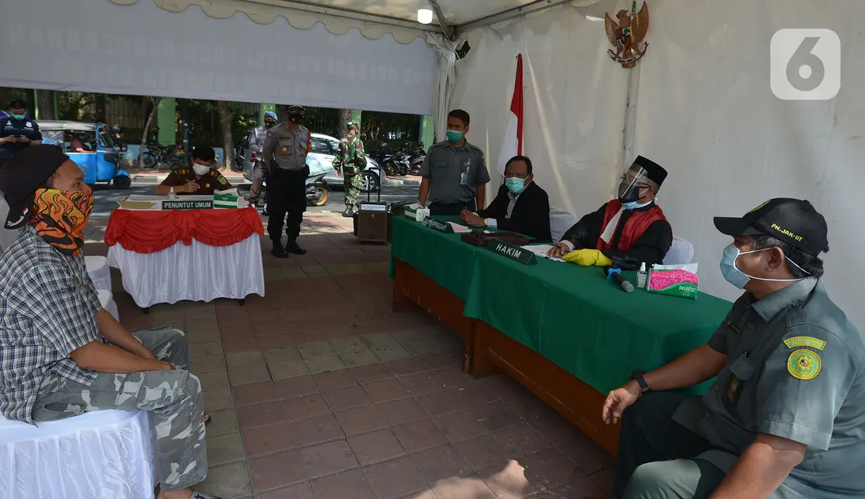 Pelanggar mengikuti sidang di tempat saat Operasi Yustisi di Kawasan Danau Sunter, Jakarta, Rabu (16/9/2020). Warga yang melanggar protokol Covid-19 langsung disidang tindak pidana ringan (tipiring) di tempat dengan membayar denda Rp 55.000 maupun sanksi sosial. (merdeka.com/Imam Buhori)