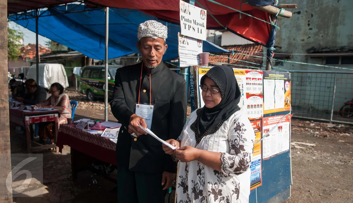 Petugas KPPS mengenakan pakaian adat dan belangkon memberikan pelayanan kepada warga yang menggunakan hak pilih di TPS 14 Cipinang Besar Selatan, Jakarta, Rabu (19/4). (Liputan6.com/Gempur M. Surya)