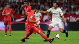 Pemain Sevilla, Franco Vazquez membawa bola dari kawalan bek Real Madrid Nacho saat bertanding pada lanjutan La Liga Spanyol di stadion Sanchez Pizjuan (26/9).  Sevilla menang telak 3-0 atas Madrid. (AP Photo/Miguel Morenatti)