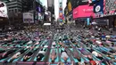 Warga ambil bagian berlatih yoga bersama di kawasan Times Square, New York pada 'Summer Solstice' atau hari dengan siang terpanjang di musim panas, Rabu (21/6). Acara itu menandai Hari Yoga Internasional yang jatuh pada 21 Juni. (TIMOTHY A. CLARY/AFP)