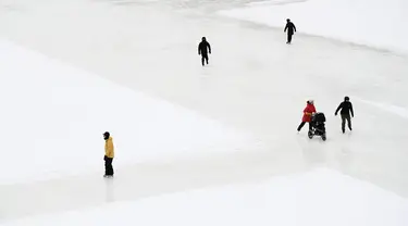 Orang-orang menyusuri Rideau Canal Skateway pada hari pembukaannya di tengah pandemi COVID-19 di Ottawa, Ontario, Kamis (28/1/2021). Kanal Rideau adalah Situs Warisan Dunia UNESCO. (Justin Tang/The Canadian Press via AP)