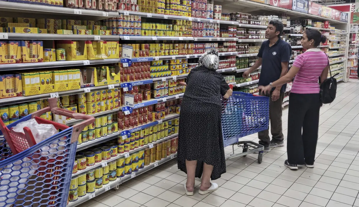 Orang-orang berbelanja di sebuah supermarket, di Tunis, Tunisia, pada 10 Oktober 2022. Gula, minyak sayur, beras, bahkan air kemasan – warga Tunisia telah menderita kekurangan beberapa bahan pokok dalam beberapa pekan terakhir. Dan biaya melonjak pada produk yang masih tersedia. (AP Photo/Hassene Dridi)