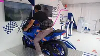 Keseruan pengunjung bermain simulator di booth XL di Sirkuit Mandalika. (Hendry Wibowo/Bola.com)