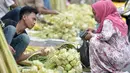 Pedagang melayani pembeli kulit ketupat untuk lebaran, Jakarta, Kamis (22/6). Menjelang Hari Raya Idul Fitri, pedagang kulit ketupat musiman mulai ramai di pasar tradisional. (Liputan6.com/Yoppy Renato)