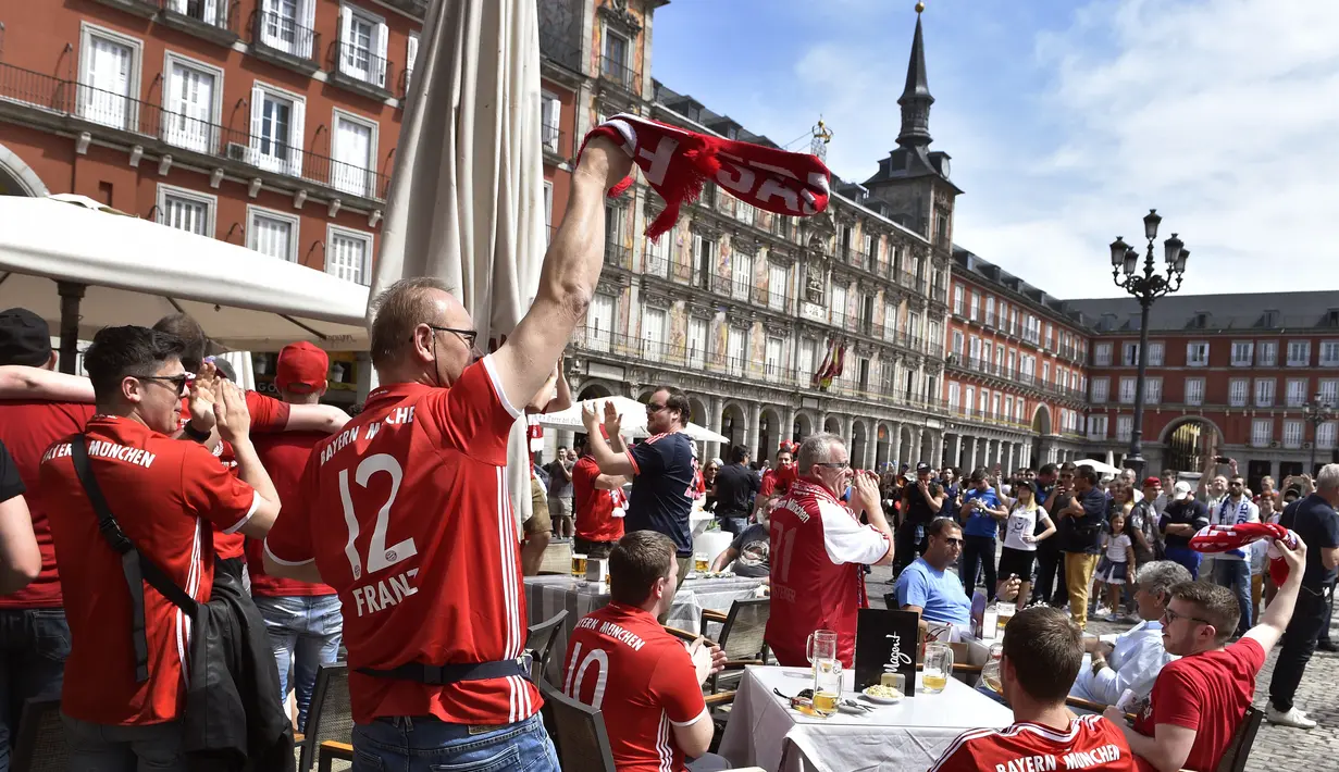Para suporter Bayern Muenchen berkumpul di teras bar di Plaza Mayor sebelum pertandingan leg kedua perempat final Liga Champions antara Real Madrid dan Bayern Muenchen di stadion Santiago Bernabeu, Spanyol (18/4). (AFP Photo / Gerard Julien)