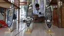 Pengrajin membuat sovenir papan seluncur di Bali, Senin (15/10). KUR yang disediakan pemerintah untuk sektor pariwisata sebagai upaya pengembangan destinasi di Indonesia. (Liputan6.com/Angga Yuniar)
