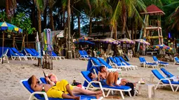 Orang-orang bersantai saat para turis memanfaatkan program "Kotak Pasir Phuket" untuk pengunjung yang divaksinasi penuh terhadap virus corona Covid-19 di pulau Phuket Thailand (25/10/2021). (AFP/Mladen Antonov)