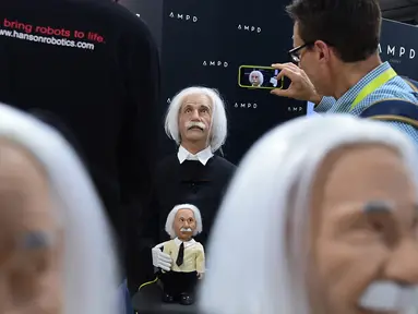 Pengunjung mengabadikan robot berwajah Profesor Albert Einstein ciptaan Hanson Robotics selama Consumer Electronic Show (CES) 2017 di Las Vegas, Nevada, AS (5/1).  Robot ini dapat digunakan melalui android dan Apple tablet. (AFP Photo/ Frederic J. Brown)