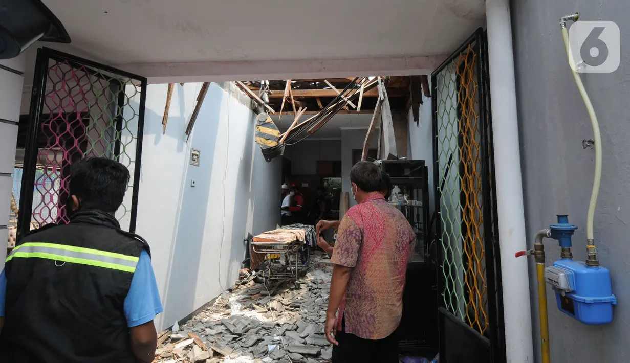 Kondisi rumah warga yang tertimpa beton akibat tergulingnya truk crane di Jalan Mawar, Perumnas Depok Jaya, Depok, Jawa Barat, Jumat (15/10/2021). Truk crane di kawasan Proyek PDAM terguling dan menimpa rumah menyebabkan tiga warga mengalami luka serius. (merdeka.com/Arie Basuki)