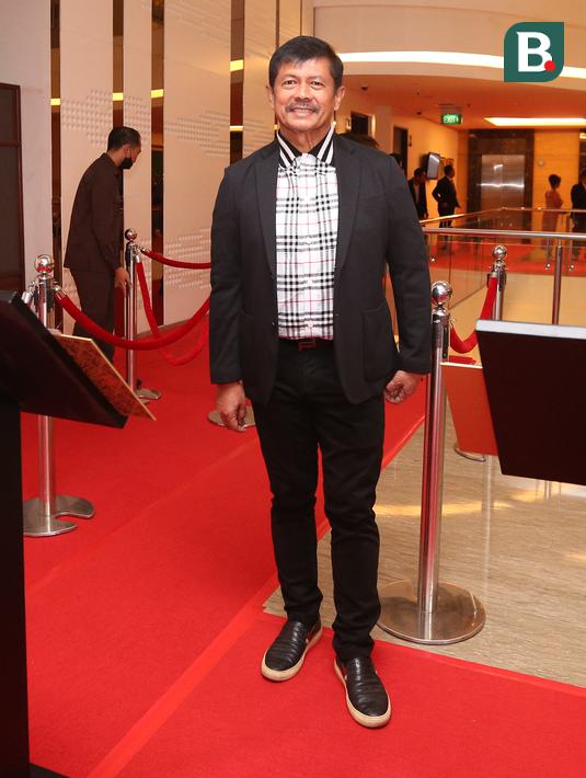 Pelatih kepala Timnas Indonesia U-22, Indra Sjafri berjalan di atas karpet merah pada sebuah acara yang berlangsung di Hotel JS Luwansa, Kuningan, Jakarta, Rabu (19/07/2023). Coach Indra terlihat mengenakan jas hitam dipadukan dengan kemeja bermotif kotak-kotak. (Bola.com/Bagaskara Lazuardi)