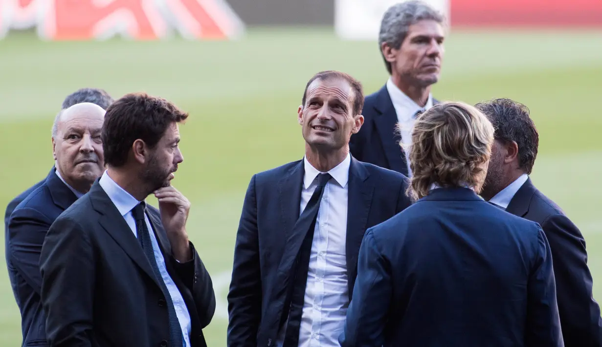 Pelatih Juventus, Massimiliano Allegri (tengah) berbincang dengan petinggi klub di lapangan stadion Camp Nou di Barcelona, Spanyol (11/9). Juventus akan menghadapi Barcelona pada laga pertama penyisihan grup D Liga Champions. (AFP Photo/Jaime Reina)