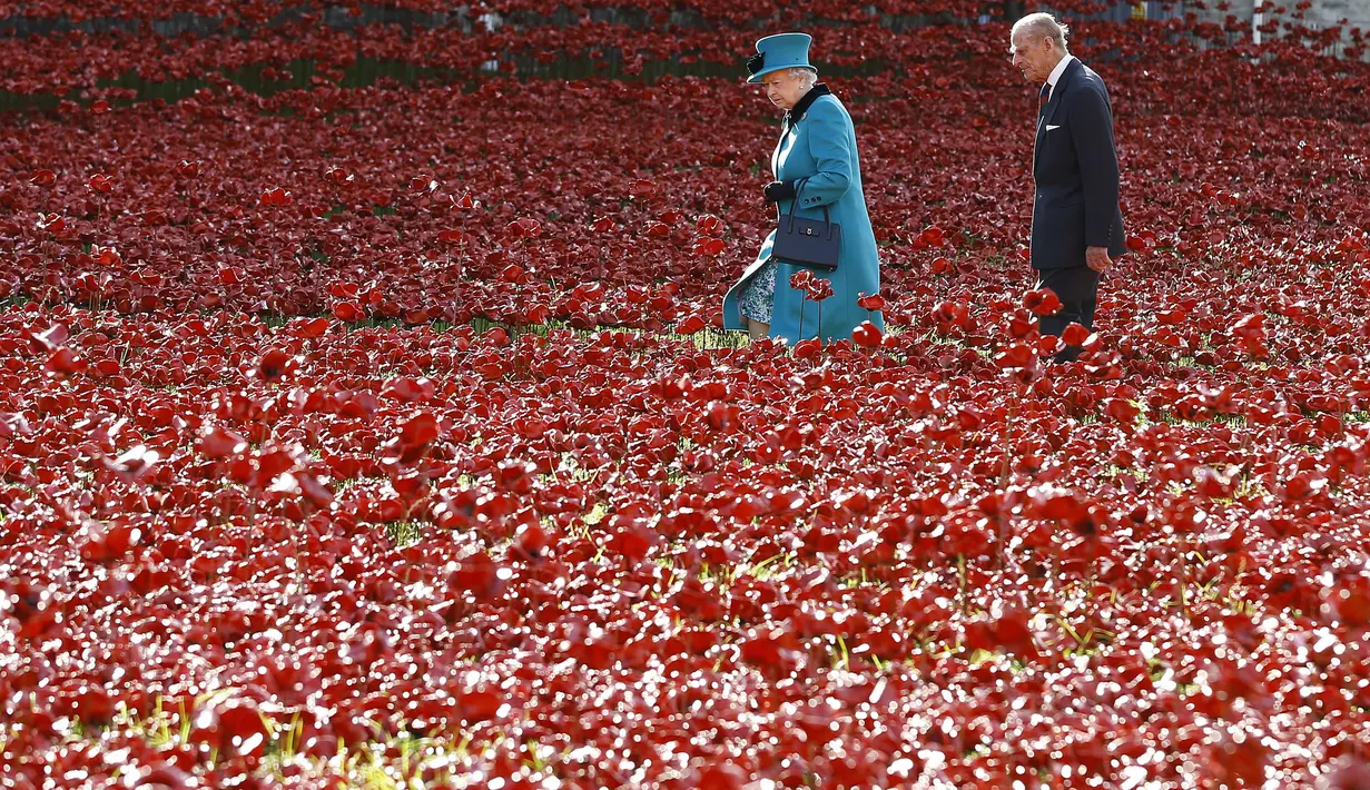 Dalam file foto 16 Oktober 2014 ini memperlihatkan Ratu Inggris Elizabeth II (kiri) dan Pangeran Philip berjalan melewati mengunjungi instalasi poppy 'Blood Swept Lands and Seas of Red' di The Tower of London. (AP Photo/Kirsty Wigglesworth, File)