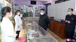 Pemimpin Korea Utara Kim Jong Un mengenakan masker memeriksa apotek di tengah wabah Covid-19 di Pyongyang, Korea Utara pada 15 Mei 2022. Total sekarang menjadi 1.483.060 dengan gejala demam, sementara jumlah kematian bertambah menjadi 56 orang. (STR/KCNA VIA KNS/AFP)
