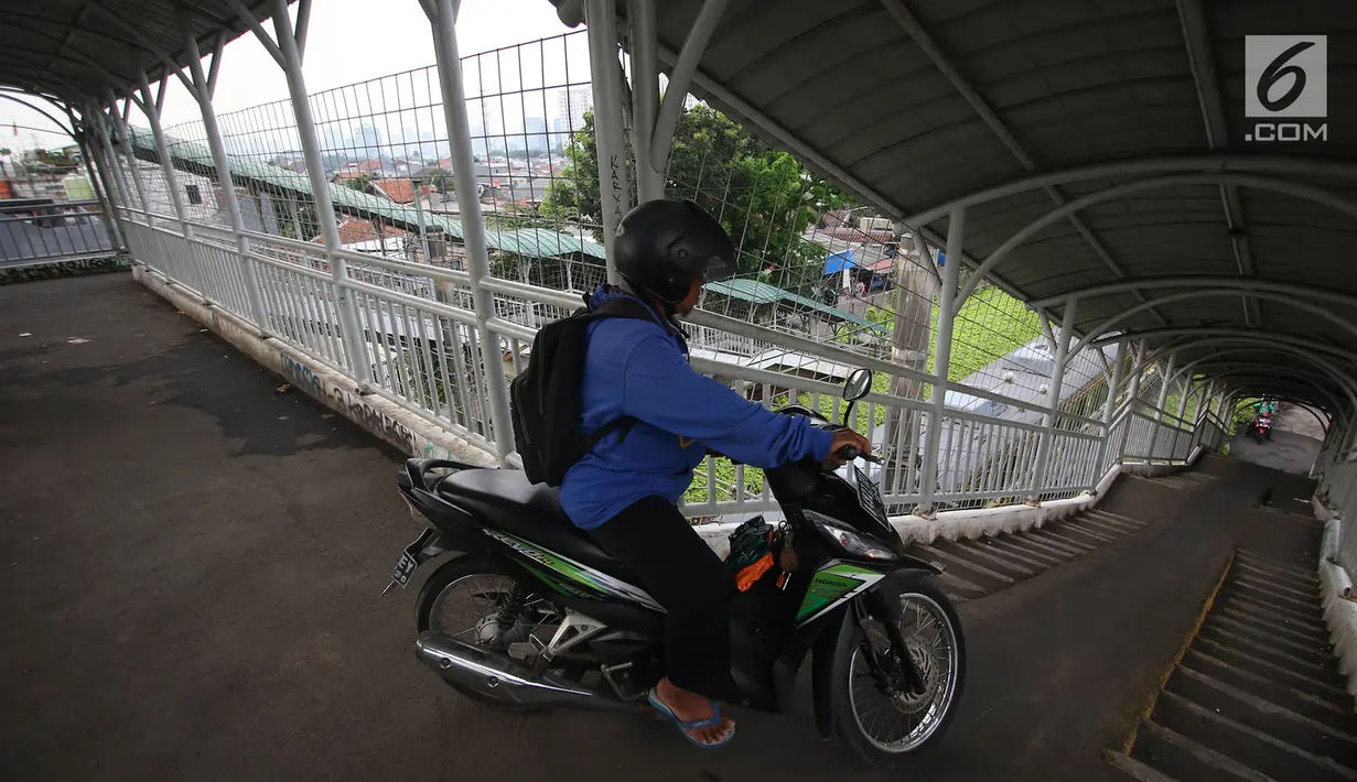 Pengendara motor memanfaatkan JPO (jembatan penyeberangan orang) di kawasan Pasar Minggu, Jakarta, Selasa (17/10). Aksi tidak tertib tersebut mengganggu hak pejalan kaki dan berpotensi membahayakan pengguna JPO. (Liputan6.com/Immanuel Antonius)