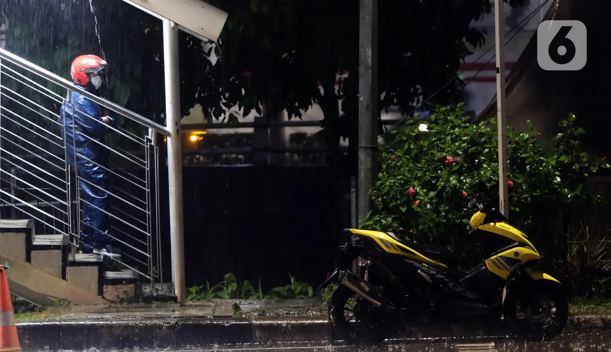 Pengendara motor mengenakan jas hujan berteduh di Jembatan Penyebrangan Orang saat hujan deras di kawasan Kuningan, Jakarta, Selasa (8/11/2022). Badan Meteorologi Klimatologi dan Geofisika (BMKG) memprakirakan puncak musim hujan di sebagian wilayah di Indonesia terjadi di bulan Desember 2022 hingga Januari 2023. (Liputan6.com/Helmi Fithriansyah)