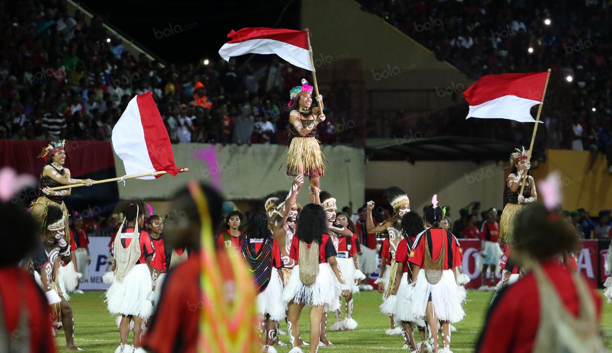 Penari mengibarkan bendera Merah-Putih saat acara pembukaan Torabika Soccer Championship 2016 di Stadion Mandala, Jayapura, Papua, Jumat (29/4/2016). (Bola.com/Nicklas Hanoatubun)