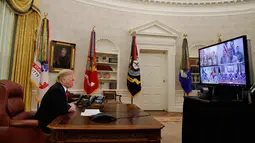 Presiden AS Donald Trump berbicara dengan prajurit militer melalui konferensi video di Gedung Putih, Selasa (25/12). Prajurit tersebut ditempatkan di Guam, Qatar, Alaska, dan dua kelompok di Bahrain. (AP Photo/Jacquelyn Martin)