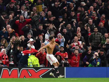Penyerang Manchester United, Cristiano Ronaldo berselebrasi usai mencetak gol ke gawang Villarreal pada menit ke 90 + 5 dalam pertandingan grup F Liga Champions di stadion Old Trafford, Inggris, Kamis (30/9/2021). Manchester United menang tipis atas Villareal 2-1. (AFP/Anthony Devlin)