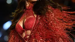 Model asal Rusia, Irina Shayk tampil percaya diri mengenakan lingerie merah dalam fashion show Victoria's Secret di Paris, Rabu (30/11).  Irina berusaha menutupi perut buncitnya di atas catwalk pagelaran pakaian dalam ternama tersebut. (Martin BUREAU/AFP)