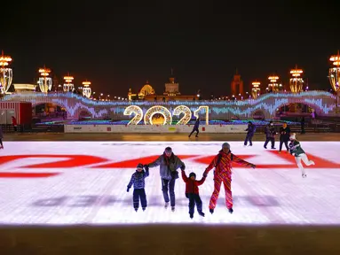 Sejumlah orang berseluncur saat pembukaan arena seluncur es di VDNKh (Pameran Prestasi Ekonomi Nasional), Moskow, Rusia, Jumat (27/11/2020). Area tersebut terbuat dari lapisan es buatan lebih dari 20.000 meter persegi. (AP Photo/Alexander Zemlianichenko)