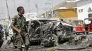 Seorang anggota pasukan keamanan berjalan melewati reruntuhan di lokasi pemboman di Mogadishu, Somalia (13/2/2021). Bom mobil meledak di Mogadishu, Somalia di luar kompleks parlemen dan tak jauh dari Istana Kepresidenan Somalia. (AP Photo/Farah Abdi Warsameh)