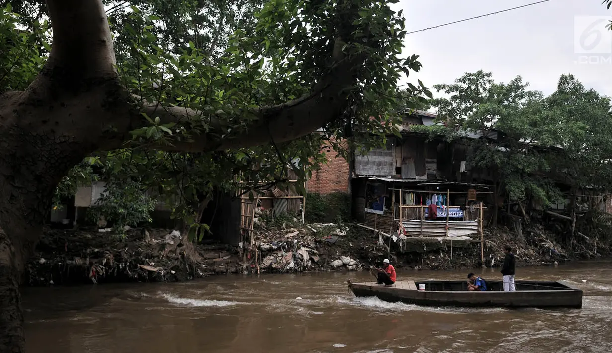 Warga mengantarkan penduduk lainnya menyeberangi Kali Ciliwung dengan jasa perahu eretan, Jakarta, Kamis (12/4). Relokasi bangunan liar di sekitar kali nantinya bakal dilakukan untuk mengembalikan fungsinya. (Merdeka.com/Iqbal Nugroho)