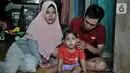 Fauziah Afiqa (tengah) berpose dengan ayah dan ibunya di kediamannya di Kampung Bulak Sentul, Harapan Jaya, Bekasi, Jawa Barat, Kamis (10/10/2019). Afiqa merupakan keturunan Betawi asli pasangan Ahmad Fauzi (26) dan Dian Irna Kurniawati (25). (merdeka.com/Iqbal Nugroho)