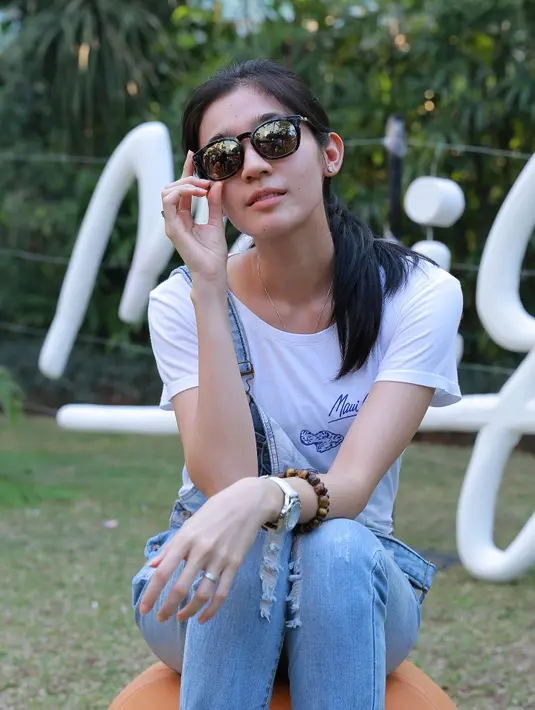 Dhini sangat suka berlibur ke pantai, dan menurutnya kacamata dapat membuatnya lebih percaya diri saat liburan. (Galih W.Satria/Bintang.com)