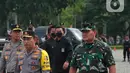 Panglima TNI Laksamana TNI Yudo Margono (kanan) dan Kapolri Jenderal Listyo Sigit Prabowo saat mengecek pasukan dalam apel Operasi Lilin 2022 di Monas, Jakarta, Kamis (22/12/2022). Selain TNI dan Polri, apel ini juga diikuti oleh instansi terkait. (Liputan6.com/Angga Yuniar)