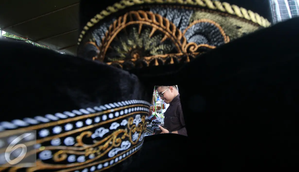 Pengunjung memilih peci yang di tawarkan dengan kisaran harga Rp 5000 hingga Rp 55.000 di halaman masjid Ageng, Solo, Jawa Tengah, Sabtu (25/6). Omzet penjualan pedagang mengalami peningkatan selama bulan ramadan. (Liputan6.com/Boy Harjanto)