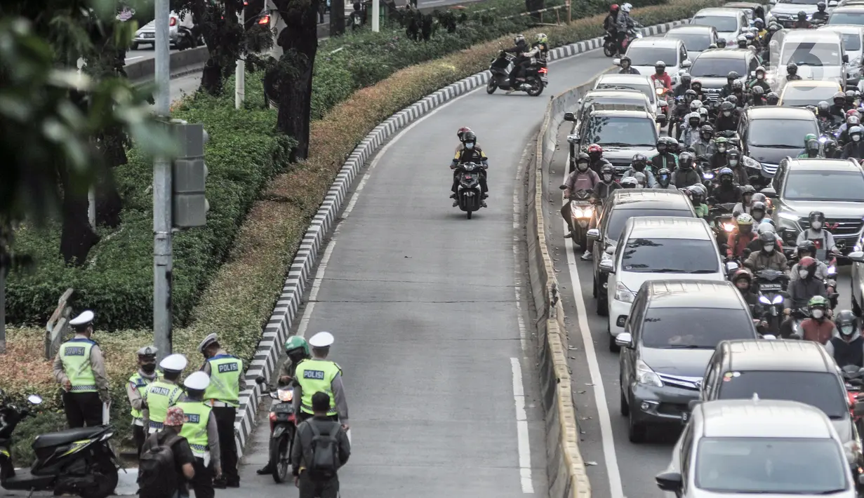 Anggota Satlantas Polres Metro Jakarta Pusat memberhentikan pengendara sepeda motor yang menerobos jalur Bus Transjakarta sementara pengendara lainnya berputar arah di Jalan Kramat Raya, Kecamatan Senen, Jakarta, Kamis (21/7/2022). Razia digelar untuk menindak para pengendara yang tidak disiplin demi menghindari kemacetan serta mencegah terjadi kecelakaan di jalur Bus Transjakarta. (merdeka.com/Iqbal S. Nugroho)