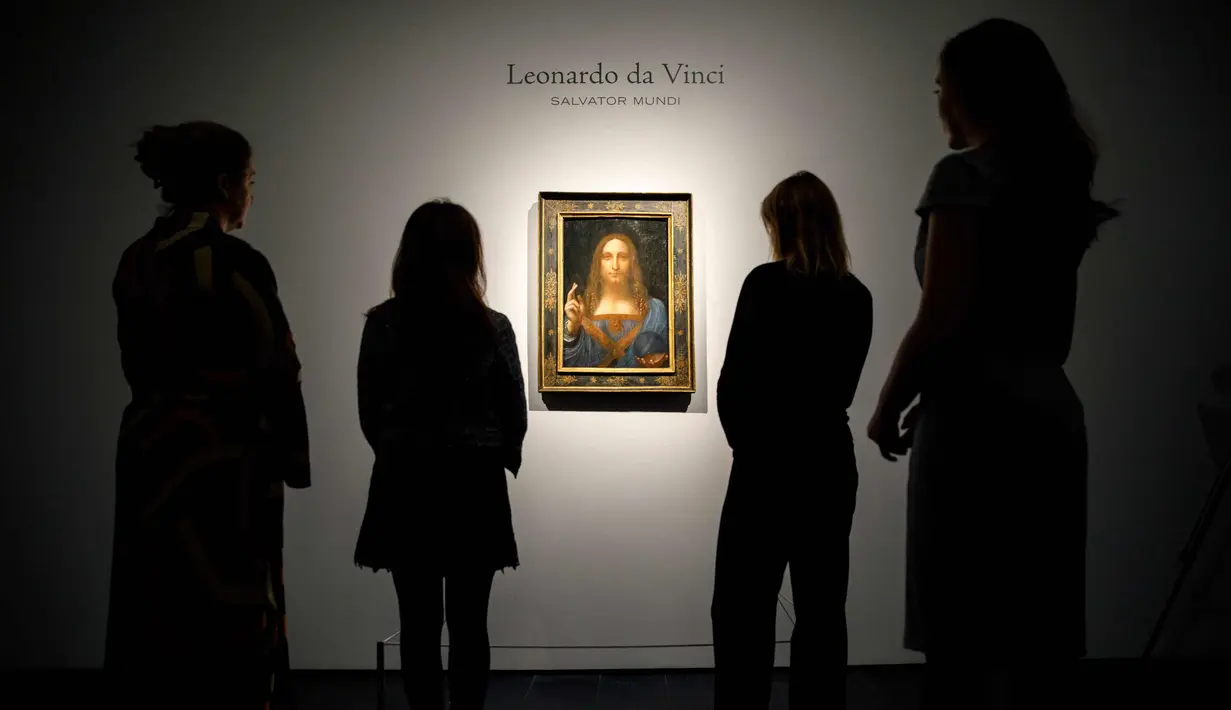 Pekerja melihat lukisan mahakarya Leonardo da Vinci berjudul 'Salvator Mundi' di rumah lelang Christie di London, Inggris (22/10). Lukisan ini akan di jual pada tanggal 15 November 2017 di Christie's New York. (AFP Photo/Tolga Akmen)