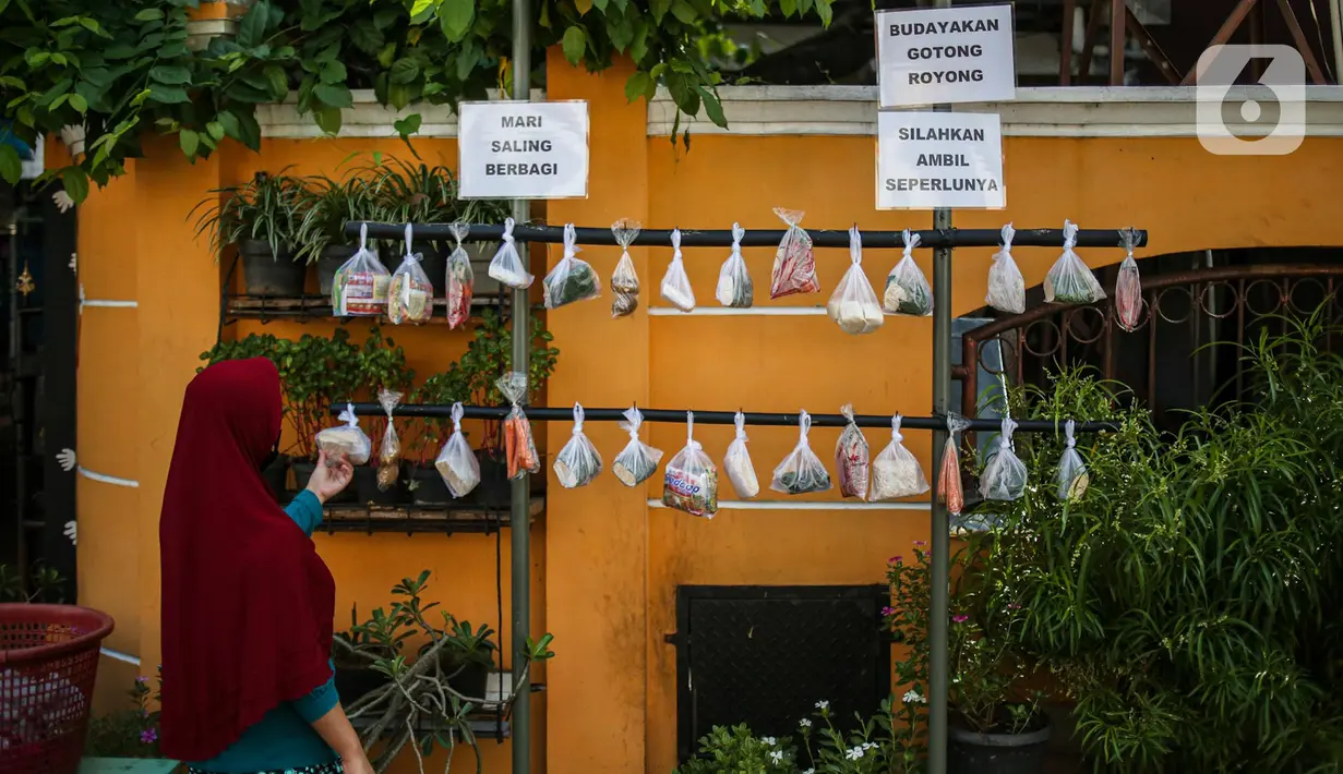 Warga memilih sayur mayur hasil sumbangan di RT 02 RW 04, Kelurahan Jati Padang, Jakarta, Jumat (22/5/2020). Pakaian bekas layak pakai serta sayur mayur disediakan bagi warga terdampak Pembatasan Sosial Berskala Besar (PSBB) untuk pencegahan COVID-19. (Liputan6.com/Faizal Fanani)
