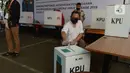 Petugas memasukan surat pemungutan suara dalam pemilihan serentak 2020 saat simulasi di Halam Kantor KPU, Jakarta, Rabu (22/7/2020). Simulasi pemungutan suara di TPS dengan menerapkan protokol kesehatan Covid-19. (merdeka.com/Imam Buhori)