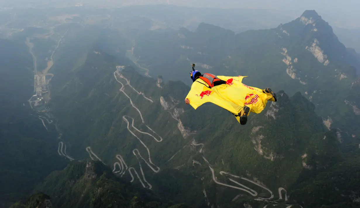 Seorang atlet terbang dengan wingsuit dari Gunung Tianmen di Zhangjiajie, Privinsi Hunan, Tiongkok, (18/10/2015). (China Out/AFP Photo)